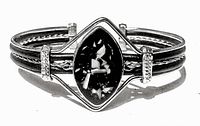 Front view of vintage mother of pearl bangle showing marquise black centerpiece with shell fragments and decorative silver-tone bands with rhinestones.