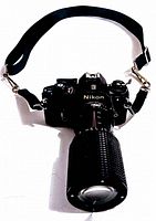 Front view of the Nikon camera with attached Tokina zoom lens and black carrier strap.