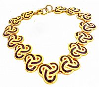 Front angle showing the linked trinity knot motifs and toggle clasp. Necklace arranged in circular form on white background.