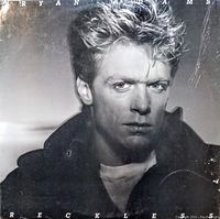 Front cover of Bryan Adams 'Reckless' vinyl record showing the black and white portrait of Bryan Adams, with visible wear and scuff marks on the cover.