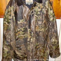 Front view of large men's camouflage raincoat showing leaf pattern and front pockets