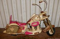 Full side view of handcrafted wooden Harley Davidson motorcycle model showing detailed wood carving with red painted accents and wood burned logo on gas tank.