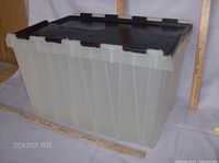 Side and perspective view of large translucent plastic storage container with black lid.