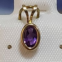 Front view of 14K yellow gold pendant showcasing the oval faceted amethyst gemstone.