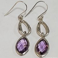 Pair of sterling silver earrings with faceted purple amethyst stones and drop hooks, front view.