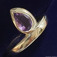 Close-up front angle of sterling silver ring with pear-shaped amethyst gemstone showing polished band detail.