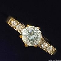 Close-up, front-facing image of the sterling silver ring featuring a large round moissanite center stone and accent stones on the band.