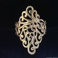 Close-up angled view of the sterling silver filigree ring showing the detailed swirling pattern.