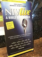 Front cover of the audio Bible set titled 'NIV live A Bible Experience' featuring a microphone image and promotional text about the dramatic performance and bonus materials on CDs.