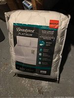 Full view of Beautyrest Platinum mattress pad in original packaging with label showing brand and size.