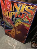Full view of boarded Janis Joplin concert poster leaning against wall