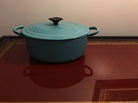 Front-left view of the turquoise oval pot with lid in place