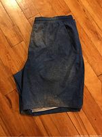 Image of dark navy athletic shorts folded to show side profile and hem