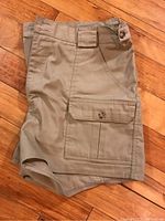 Front view of khaki Tilley safari shorts showing front buttoned flap pocket, belt loops, and overall design