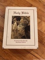 Closed box view of the Holy Bible illustrated edition by Norman Rockwell showing cover art on front with title.