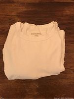 White Rough Dress T-shirt folded with visible label inside collar.