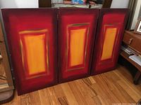 Full view of all three panels leaning against wall on wood floor