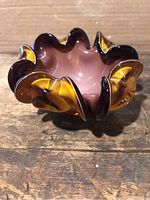 Ruffled glass dish with amber and brown tones, pink interior.