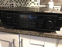 Front view showing entire receiver unit on countertop with digital display illuminated showing FM frequency 96.3 MHz and volume 10.