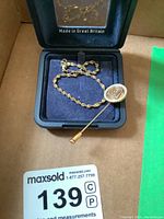 Bracelet and lapel pin resting in presentation box marked Made in Great Britain