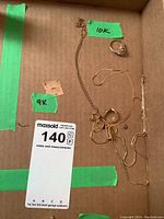 Overview of all jewellery in box with 10k and 9k labels and lot tag
