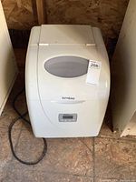 Front and top view of white Danby Ice N Easy ice maker showing transparent lid and digital panel.