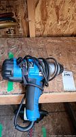 Mastercraft impact wrench angled view showing blue and black tool with cord coiled around handle on wooden surface