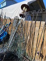 Wider shot showing several trellises and the bird feeder leaning against fence