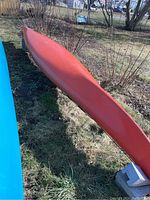 Full length view of orange kayak hull showing bow to stern shape