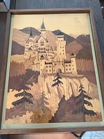 Full view of the framed wood inlay art showing the castle, trees, cliff, and mountains.