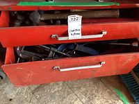 Photo of two red metal drawers containing assorted old hammers, mallets, metal tools such as vices and wrenches, showing the range and condition of the contents.