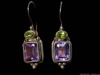 Front view of the earrings showing green oval and purple rectangular stones set in sterling silver with hook wires.