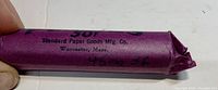 Close-up of purple paper roll showing manufacturer and handwritten labeling