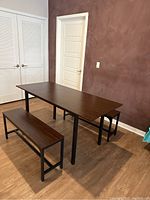 Full view of the dining table extended with two benches placed on the ends.