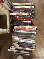 Stack of DVDs and Xbox 360 games showing titles such as The Parent Trap, Shrek, Pirates of the Caribbean, Kinect Disneyland Adventures, Sonic Generations