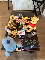 Full view of all items on table including stuffed toys, Funko Pop figure, pillow, and chess/checkers board