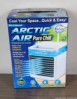 Photo of original box packaging with product branding and feature highlights such as energy efficiency, silent operation, personal space cooler, and humidifying function.