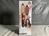 Photo of box showing front of the Conair Volume Series curling iron and brush set with image of product and model.
