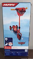 Front side of the scooter box displaying the product photo and logos, showcasing the 3-wheel design and age recommendation.
