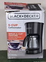 Box showing branding and key features like 5-cup capacity and Sneak-A-Cup feature.