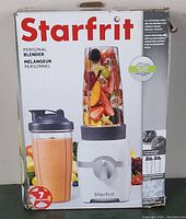 Box front of Starfrit personal blender with image of blender and fruit inside blending bottle with text.