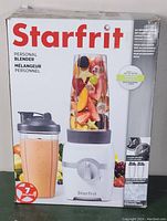Box of Starfrit personal blender showing multiple images of blender, cups, and lids. Box design notes 7 pieces included, multiple blades, and dishwasher safe parts.