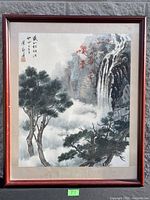 Full view of framed watercolor painting depicting a mountain landscape with waterfall and pine trees. Misty atmosphere and traditional Chinese style.