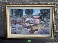 Full view of framed painting leaning against a brick wall outdoors