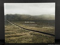 Front cover of 'Border Cantos' showing aerial desert photograph with border wall.