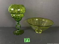 Photo showing the tall green glass vase and green glass bowl side by side on a black surface.