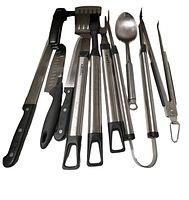 Photo showing a collection of metal and plastic kitchen utensils including knives, tongs, spatulas, and skewers with black and stainless steel handles.
