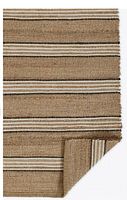 Close-up photo of the jute/sisal striped brown rug showing natural brown and white horizontal stripes with folded corner.