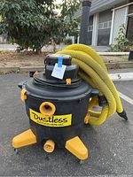 Front view of vacuum with yellow hose coiled on top
