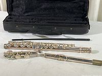 Flute body pieces, cleaning rod, and open padded case shown together to illustrate all included items.